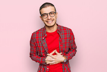 Hispanic young man wearing casual clothes smiling and laughing hard out loud because funny crazy...