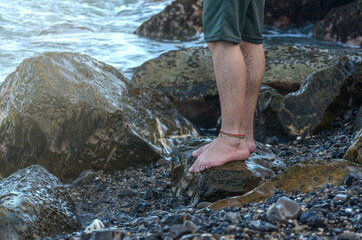Man legs on rock beach coast