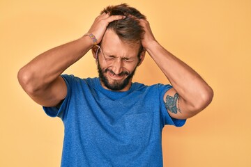 Fototapeta na wymiar Handsome caucasian man with beard wearing casual clothes suffering from headache desperate and stressed because pain and migraine. hands on head.