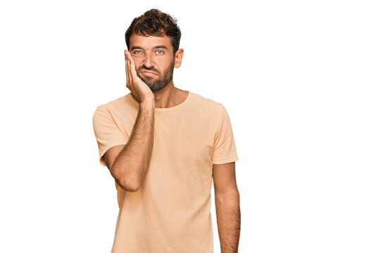 Handsome young man with beard wearing casual tshirt thinking looking tired and bored with depression problems with crossed arms.