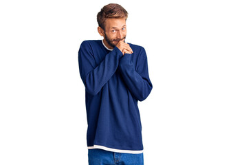 Handsome blond man with beard wearing casual sweater laughing nervous and excited with hands on chin looking to the side