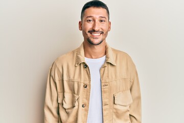 Obraz premium Handsome man with tattoos wearing casual brown denim jacket with a happy and cool smile on face. lucky person.