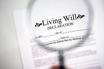 Living will declaration form seen through magnifying glass.