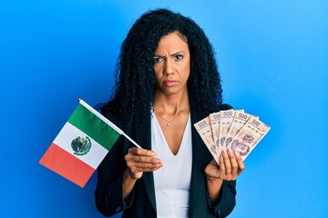 Middle age african american woman holding mexico flag and mexican pesos banknotes depressed and worry for distress, crying angry and afraid. sad expression.