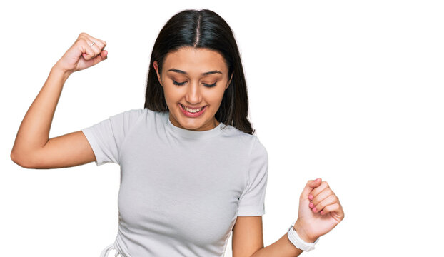 Young hispanic girl wearing casual white t shirt dancing happy and cheerful, smiling moving casual and confident listening to music