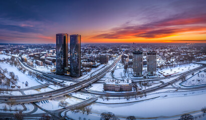 Riga city panorama at colorful sunset in blue hour. Modern skyscrapers next to picturesque view...