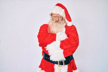 Old senior man with grey hair and long beard wearing santa claus costume skeptic and nervous, disapproving expression on face with crossed arms. negative person.