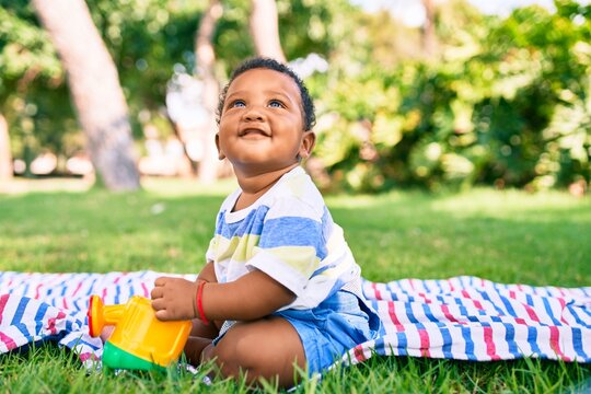 Adorable african american toddler smiling happy playing with toy at the park.