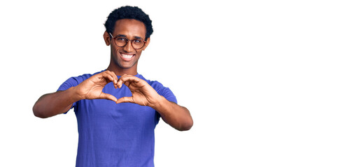 African handsome man wearing casual clothes and glasses smiling in love doing heart symbol shape with hands. romantic concept.