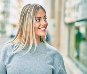 Fototapeta premium Young blonde girl smiling happy standing at the city.