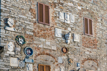 Fototapeta na wymiar The façade of Palazzo Pretorio, ancient seat of political and military power, with coats of arms and inscriptions, in Campiglia Marittima, province of Livorno, Tuscany, Italy