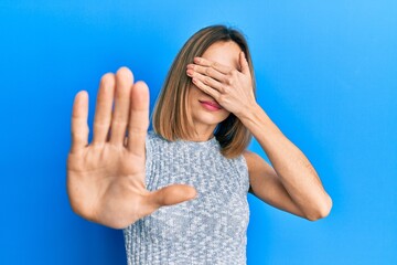 Young caucasian blonde woman wearing casual t shirt covering eyes with hands and doing stop gesture with sad and fear expression. embarrassed and negative concept.