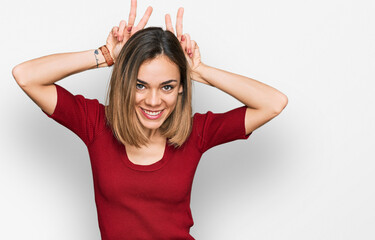 Young blonde girl wearing casual clothes posing funny and crazy with fingers on head as bunny ears, smiling cheerful