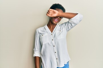 Young african american girl wearing casual clothes covering eyes with arm smiling cheerful and funny. blind concept.