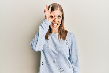 Beautiful caucasian woman wearing casual clothes smiling happy doing ok sign with hand on eye looking through fingers