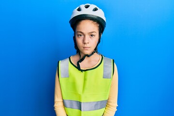 Beautiful brunette little girl wearing bike helmet and reflective vest skeptic and nervous, frowning upset because of problem. negative person.