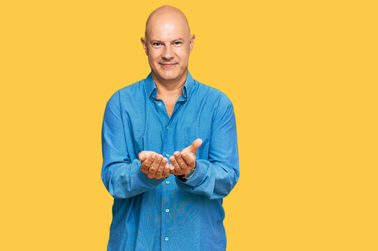 Middle age bald man wearing casual clothes smiling with hands palms together receiving or giving gesture. hold and protection