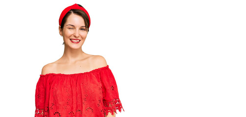 Young brunette woman with short hair wearing casual summer clothes and diadem winking looking at...
