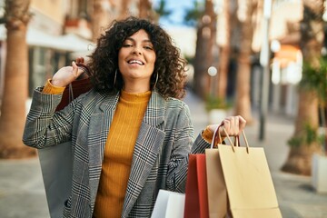 Young hispanic woman going shopping at the city.