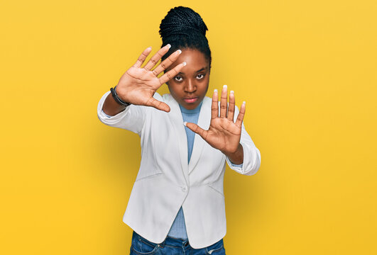 Young african american woman wearing business clothes doing frame using hands palms and fingers, camera perspective