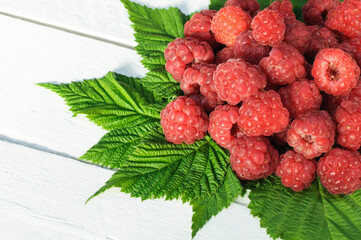 Fresh raspberries on white wooden background