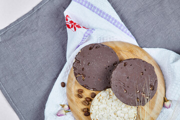 Rice and chocolate crackers on a wooden plate with a tablecloth