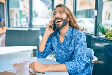 Young middle eastern man talking on the smartphone at coffee shop.