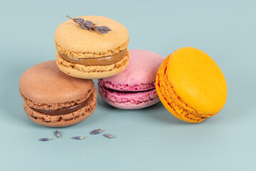 Cake macaron or macaroon on turquoise background from above, colorful almond cookies, pastel colors, vintage card