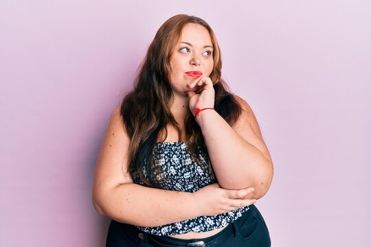 Plus size caucasian young woman wearing casual clothes thinking concentrated about doubt with finger on chin and looking up wondering