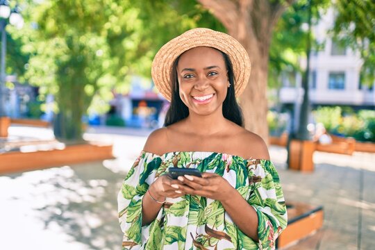 Young african american tourist woman on vacation smiling happy using smartphone at the city.