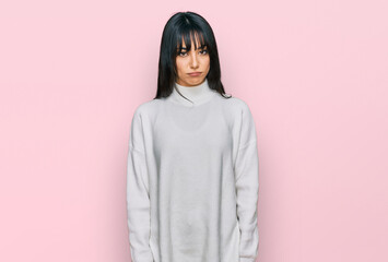 Young brunette woman with bangs wearing casual turtleneck sweater depressed and worry for distress, crying angry and afraid. sad expression.