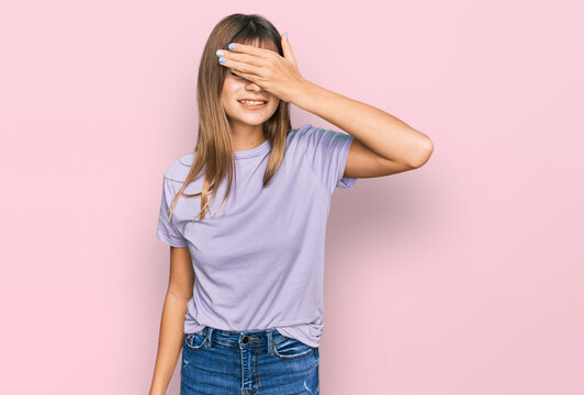 Teenager caucasian girl wearing casual clothes smiling and laughing with hand on face covering eyes for surprise. blind concept.
