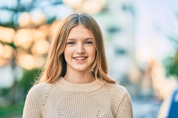 Fototapeta premium Beautiful caucasian teenager smiling happy standing at the city.