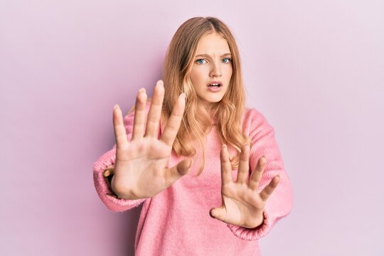 Beautiful young caucasian girl wearing casual clothes doing stop gesture with hands palms, angry and frustration expression