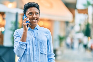 Young african american girl smiling happy talking on the smartphone at the city.