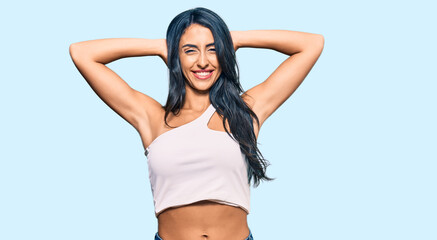 Obraz premium Beautiful hispanic woman wearing casual clothes relaxing and stretching, arms and hands behind head and neck smiling happy