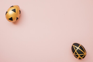 Easter golden decorated eggs on pastel pink background. Minimal easter concept. Happy Easter card with copy space for text. Top view, flatlay