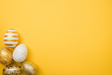 Easter golden decorated eggs on yellow background. Minimal easter concept. Happy Easter card with...