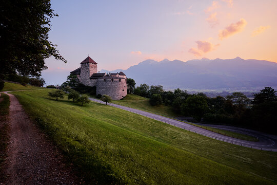 Vaduz Castle, the official residence of the Prince of Liechtenstein, with Alps mountains in background on sunset.