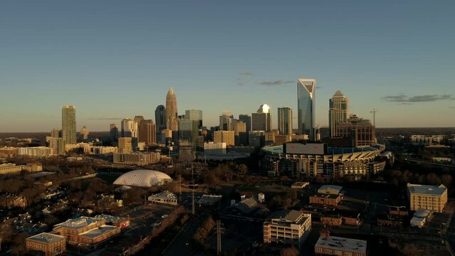 Aerial Helicopter View Downtown Charlotte North Carolina Sun Set Blue Sky Stadium Punters toll buildings Banks and horizon camera moves slow