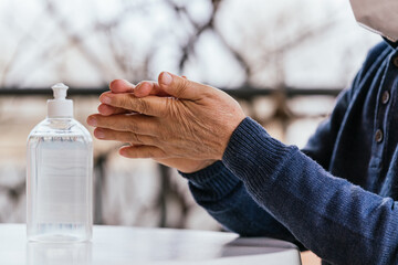 Closeup shot of the hands of a male using a hand sanitizer - the concept of new normal