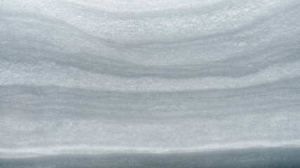 Arrangement of the layers in a snowdrift, snow texture, snowdrift texture. Compressed layers of snow for the backdrop. Smooth contour lines of the layer.