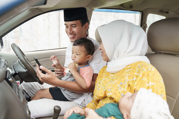 portrait of Muslim family travel by car and talk using video call on their phone