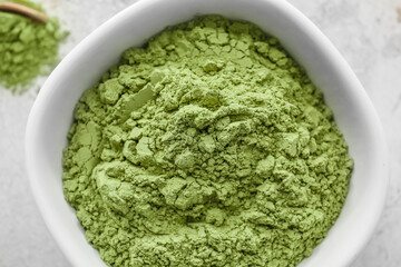 Bowl with powdered matcha tea on light background, closeup