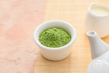 Bowl with powdered matcha tea on color background