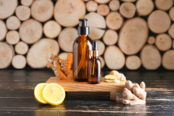 Fototapeta na wymiar Bottles with ginger essential oil on wooden background
