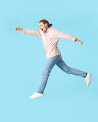 Jumping young man against color background
