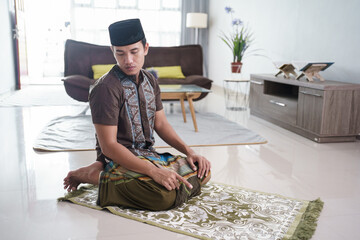 portrait of Young asian Muslim man praying at home
