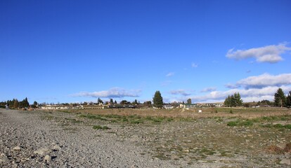 抜けるような青空の下の平地に、建物がまばらに建つ風景
