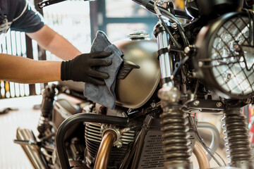 Biker man cleaning motorcycle , Polished and coating wax on fuel tank. repair and maintenance...